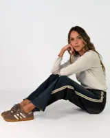 Pantalon recto bicolor con frente en denim azul y espalda en denim negro, presenta franjas laterales en tono claro y cierre frontal con botones.
