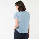 Blusa de manga corta color azul con estampado de rayas verticales blancas, cuello en pico y corte holgado.