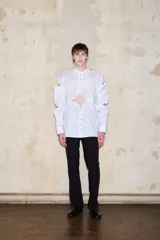 Pantalón negro de tiro alto y pierna recta, con laterales de malla transparente y cierre frontal.