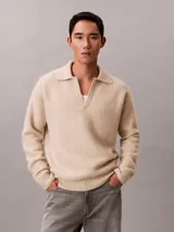 Sweater de punto de lana de alpaca cepillada, color beige, con cuello johnny y manga larga. Diseño de corte regular con puños y ruedo acanalados.