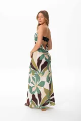 Vestido largo strapless con estampado floral en tonos verdes, marrones y beige. Tiene espalda descubierta con lazo ajustable.