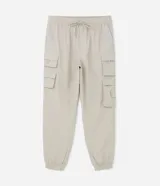 Pantalón jogger de poliamida color beige, de corte holgado con cintura elástica ajustable mediante cordón, puños elásticos en los tobillos y cuatro bolsillos cargo laterales con solapa.