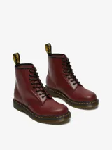 Bota Dr. Martens modelo 1460 de cuero color cereza, con 8 ojales, costuras amarillas y suela con cámara de aire.