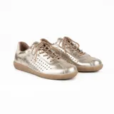 Championes deportivos de cuero natural color dorado, con perforaciones laterales para mayor ventilación, cordones al tono y suela de goma plana.