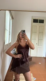 Blusa de satén color chocolate con escote en V y detalles de encaje en el borde. Posee breteles finos y un diseño asimétrico con terminación en encaje.