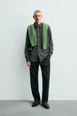 Camisa de corte regular fit confeccionada en una mezcla de lana y algodón. Presenta un diseño de cuadros pequeños, cuello solapa, manga larga con puños abotonados y cierre frontal con botones. Incluye un bolsillo en el pecho.