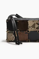 Cartera bandolera rectangular con correa ajustable negra. El cuerpo del bolso está confeccionado con un patrón de patchwork de cuadrados en cuero negro liso, gamuza marrón y estampado de piel de serpiente en tonos beige y marrón. Los paneles están unidos por grapas metálicas doradas. Posee cierre superior y forro interior.