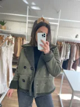 Chaqueta negra con forro tipo corderito, doble botonadura y cuello solapa.