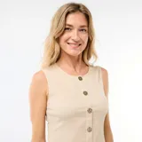 Camiseta de tirantes color beige con textura sutil, escote redondo y cierre frontal de botones decorativos oscuros y metálicos.