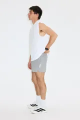 Musculosa deportiva blanca de corte holgado con cuello redondo, sisas amplias y pequeño estampado al frente.