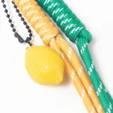 Llavero con mosquetón en forma de corazón, compuesto por dos cordones de tela trenzada en colores amarillo y verde, y un dije colgante en forma de limón.