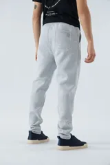Pantalón deportivo de invierno, corte clásico con bolsillos laterales y cintura elástica con cordón ajustable. Presenta logo estampado y detalle en goma.