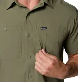 Camisa de manga corta Columbia, color verde oliva, con cuello clásico, cierre frontal de botones y dos bolsillos frontales en el pecho. Presenta un diseño técnico con ventilación en la espalda, ideal para actividades al aire libre.