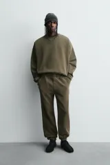 Sudadera de corte boxy fit con efecto lavado, cuello redondo con detalle de costura triangular y acabados con bordes deshilachados en el ruedo y las costuras. Presenta manga larga con puños acanalados.
