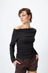 Top negro elastizado de morley, con cuello recto asimétrico que deja un hombro al descubierto y frunces laterales.