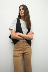 Pantalón ancho de tiro alto, color negro, con pretina y doble botón metalizado.