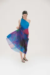 Vestido largo de fiesta con estampado abstracto en tonos azules, fucsia y violetas. Diseño de un solo hombro y falda con suave transparencia.