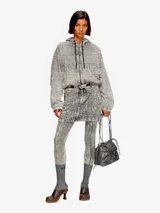 Bolso tipo cubo Diesel Scrunch-D, color gris oscuro, confeccionado en cuero brillante con efecto arrugado. Presenta logo metálico "D" en el frente, cierre con cordones ajustables, correa de hombro extraíble y múltiples bolsillos internos.