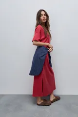 Vestido midi negro de algodón con calce relajado, silueta recta, cuello redondo, mangas cortas amplias y tajos laterales.