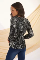 Blusa de manga larga con estampado floral en tonos verde y blanco.
