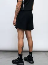 Short deportivo negro de poliéster y elastano, con logo de Umbro estampado en blanco en la pierna izquierda.