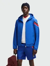 Short de baño azul con cintura elástica y cordón ajustable. Presenta una franja tricolor (rojo, negro y blanco) en el lateral y el logo de la marca en el ruedo.