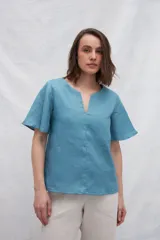 Blusa celeste de lino con escote en V y mangas cortas amplias.