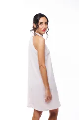 Vestido corto color rosa pálido, con cuello halter y corte recto.