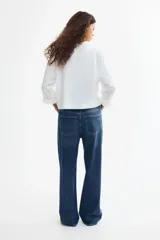 Jean wide leg de tiro alto en denim de algodón con leve elasticidad. Presenta diseño de cinco bolsillos, presillas para cinturón y cierre frontal con botón metálico.