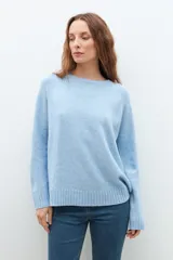 Sweater de punto en color celeste, con cuello redondo, mangas largas y puños acanalados. Presenta un diseño de corte holgado con costuras verticales decorativas en el frente.