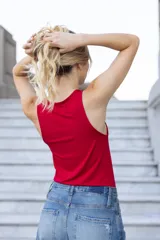 Musculosa roja de microfibra doble torsión, sin mangas, con terminación de vivos a tono en cuello y sisas, calce fit al cuerpo y largo hasta la cadera. Presenta un detalle de accesorio metálico con abertura en el escote delantero.