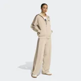 Pantalón deportivo Adidas modelo Firebird de corte holgado y tiro medio. Presenta diseño clásico con las tres rayas características de la marca en los laterales y confeccionado en tejido tricot suave.