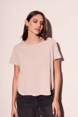 Remera color crudo de algodón peinado, de corte recto y mangas cortas. Presenta cuello redondo con detalle de cadena metálica dorada.