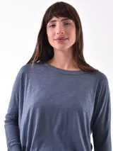 Remera blanca de manga larga con cuello redondo y corte holgado.