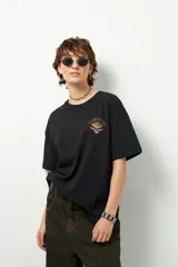 Remerón unisex verde militar de manga corta y cuello redondo, con pequeño estampado lateral en el frente y otro grande en la espalda.