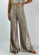 Pantalón blanco de corte palazzo, tiro alto y cintura elástica. Confeccionado en tela ligera con textura.