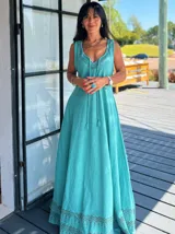 Vestido largo de algodón color celeste, con breteles finos y escote en V. Presenta un estampado geométrico en el ruedo.