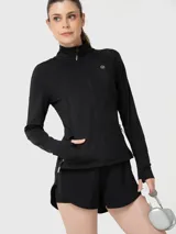 Polera deportiva negra de manga larga con cierre frontal completo, cuello alto y bolsillos laterales con cierre. Presenta un diseño ajustado con aberturas para los pulgares en los puños.