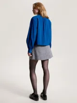 Camisa azul con cuello mao, corte cropped, mangas largas abullonadas con puño y cierre frontal con botones. Confeccionada en mezcla de modal ligera con acabado texturizado.