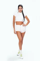 Remera deportiva blanca de corte crop top, confeccionada en tejido de punto suave al tacto.