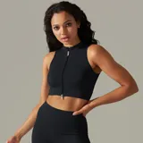 Top deportivo blanco de punto acanalado, con cuello alto y cierre frontal con cremallera.