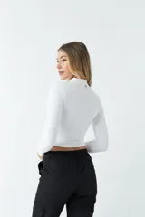 Top rojo de punto canalé, de manga larga y cuello alto con abertura en el pecho.