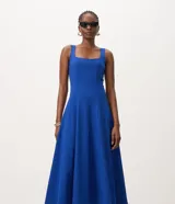 Vestido midi evasé color azul, sin mangas, con escote cuadrado, breteles medianos y recortes verticales. Fabricado por la marca Cortelle en mezcla de viscosa, poliamida y elastano con forro de poliéster.
