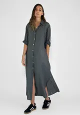 Vestido camisero largo color gris oscuro, con cuello clásico, abotonadura frontal completa, mangas 3/4 con trabillas y aberturas laterales en el ruedo.