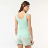 Conjunto de pijama de dos piezas en color verde menta, compuesto por una musculosa de canalé con escote redondo y detalle de pequeños bordados en el centro del pecho, y un short de patrón a cuadros vichy con terminaciones redondeadas en el bajo.