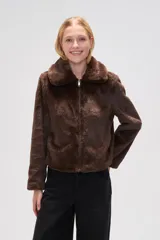 Chaqueta corta de piel sintética en color negro, con cuello clásico, cierre frontal con cremallera y mangas largas.