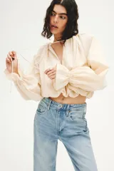 Pantalón jean de tiro alto y corte bootcut, confeccionado en denim de algodón con ligera elasticidad. Presenta diseño clásico de cinco bolsillos, cierre frontal con botón y cremallera, y perneras ligeramente acampanadas en el bajo.