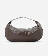 Cartera modelo hobo de gran tamaño, confeccionada en poliuretano con acabado brillante y textura suave. Presenta un diseño de media luna con asa ancha integrada para llevar al hombro y cierre superior.