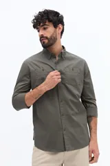 Camisa de gabardina azul marino con efecto stone wash, doble bolsillo frontal con solapa y botón, y fit regular.