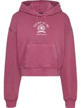 Buzo cropped de corte holgado con capucha y cordón ajustable. Presenta hombros caídos, bolsillo tipo canguro frontal y puños con terminación en punto canalé. Incluye el escudo de la marca Tommy Jeans bordado en el pecho.